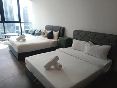 a hotel room with two beds and a couch at Scarletz Suites Klcc Twin tower by Lucky in Kuala Lumpur