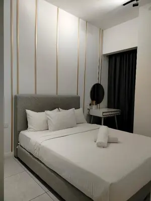 a bedroom with a large white bed and a table at skyscraper by cozy in Kuala Lumpur