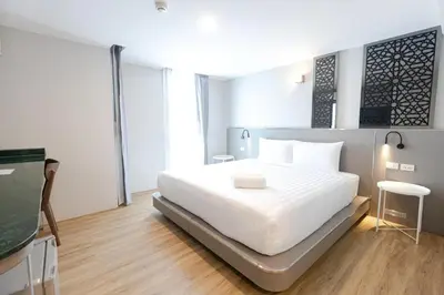 a bedroom with a white bed and a television at Lofts At Hang Kasturi Kuala Lumpur in Kuala Lumpur