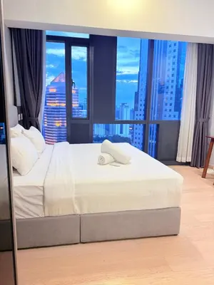 a bedroom with a bed with a view of a city at Star Residences Apartment KLCC in Kuala Lumpur