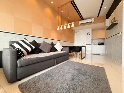 a living room with a couch and a kitchen at The Robertson Bukit Bintang by TALKS COLLECTION in Kuala Lumpur