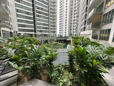 a garden in the middle of a building with tall buildings at Regalia Apartments By FA 6 in Kuala Lumpur