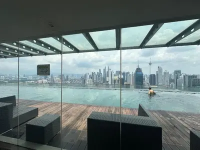 a man in a swimming pool on the roof of a building at Regalia Apartments By FA 6 in Kuala Lumpur