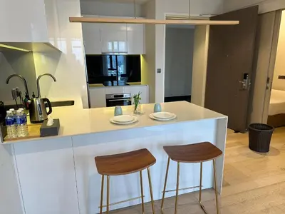a kitchen with two bar stools and a counter top at Astra Suites - Star Residence KL in Kuala Lumpur