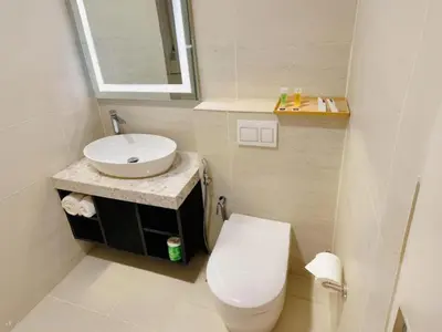 a white bathroom with a toilet and a sink at Astra Suites - Star Residence KL in Kuala Lumpur
