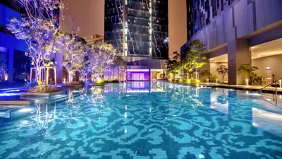 a swimming pool in the middle of a building at night at Astra Suites - Star Residence KL in Kuala Lumpur