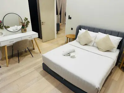 a bedroom with a bed and a desk with a mirror at Astra Suites - Star Residence KL in Kuala Lumpur
