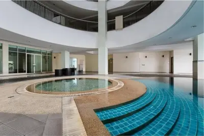 a large swimming pool in a building with a ceiling at Stylish City Hideout - Comfy Sofa, Warm Ambience in Kuala Lumpur