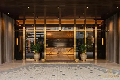 a lobby with two potted plants in front of a building at Armani Residence Kuala Lumpur in Kuala Lumpur