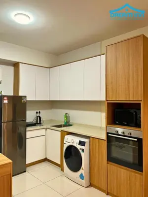 a kitchen with white cabinets and a washer and a dishwasher at Arte Mont Kiara Luxe Suites by Dream'Inn in Kuala Lumpur