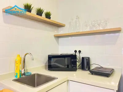 a kitchen counter with a microwave and a sink at Arte Mont Kiara Luxe Suites by Dream'Inn in Kuala Lumpur