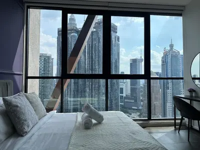 a bed in a room with a large window at Scarletz Suites KLCC Studio in Kuala Lumpur