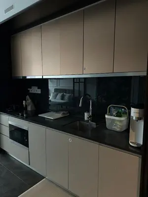 a kitchen with white cabinets and a sink at Scarletz Suites KLCC Studio in Kuala Lumpur