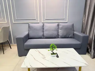 a living room with a couch and a table at The Luxe Infinity Skypool By Tasu Homes in Kuala Lumpur
