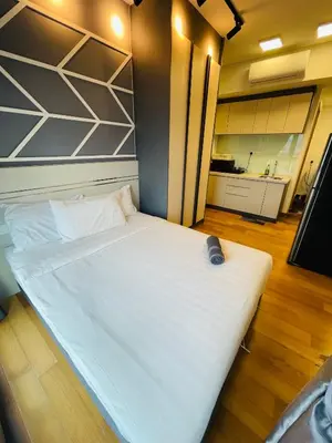a large white bed in a room with a kitchen at The Luxe Infinity Skypool By Tasu Homes in Kuala Lumpur