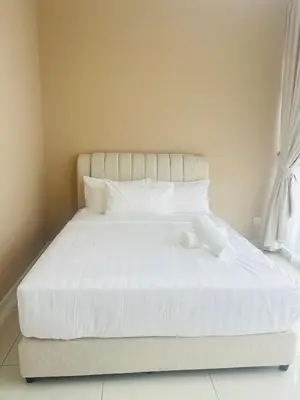 a bed with white sheets and pillows in a bedroom at Majestic Residence KLCC By Alfa in Kuala Lumpur