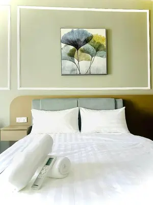 a bed with a remote control sitting on top of it at Majestic Residence KLCC By Alfa in Kuala Lumpur