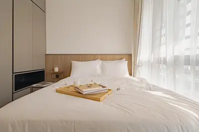a bed with a wooden tray with books on it at Novo Ampang 2 Bedrooms KLCC view in Kuala Lumpur
