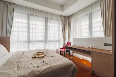 a bedroom with a bed and a desk and windows at Novo Ampang 2 Bedrooms KLCC view in Kuala Lumpur