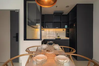 a dining room table with chairs and a kitchen at Novo Ampang 2 Bedrooms KLCC view in Kuala Lumpur