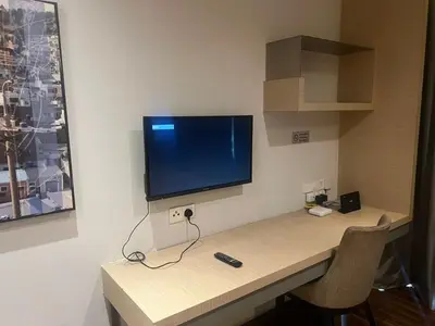 a desk with a flat screen tv on a wall at D Majestic hosted by Super Tang in Kuala Lumpur