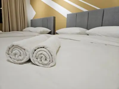 a bedroom with two white towels on a bed at CEMPAKA SUITES By VG Homes in Kuala Lumpur