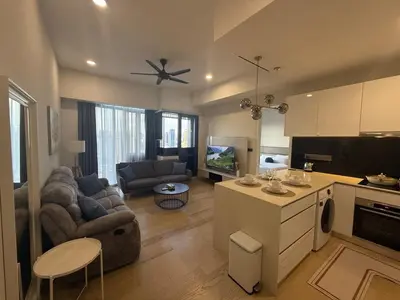 a kitchen and living room with a couch and a table at Star Residance KLCC by Nexus 13 in Kuala Lumpur