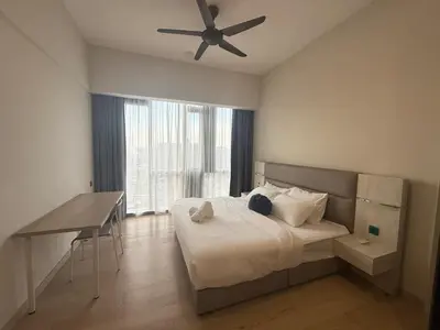 a bedroom with a bed and a desk and a ceiling fan at Star Residance KLCC by Nexus 13 in Kuala Lumpur