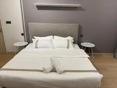 a large white bed with white pillows and two tables at Star Residance KLCC by Nexus 13 in Kuala Lumpur