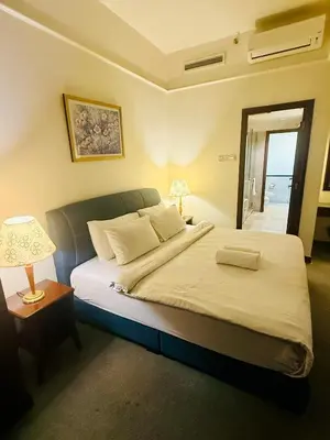 a bedroom with a bed and a lamp and a window at Times Square Kuala Lumpur by Willow Trip in Kuala Lumpur