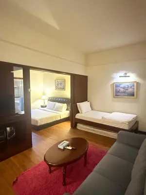 a hotel room with two beds and a couch at Times Square Kuala Lumpur by Willow Trip in Kuala Lumpur