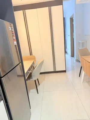 a kitchen and dining room with a table and a refrigerator at Colony Suites KL by Sopping Centre in Kuala Lumpur