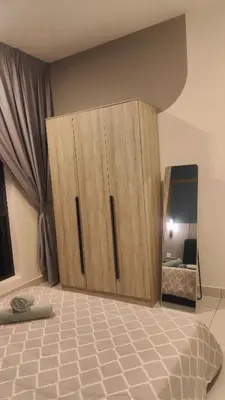 a bedroom with a wooden cabinet and a mirror at ARTE Mont Kiara Modern Sanctuary Jacuzzi in Kuala Lumpur