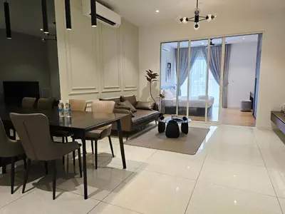 a dining room and living room with a table and a couch at Quill Residence Queen House in Kuala Lumpur