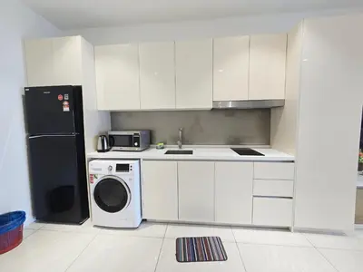 a kitchen with a washing machine and a refrigerator at Quill Residence Queen House in Kuala Lumpur