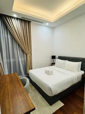 a hotel room with a bed and a table at Royce Residence KLCC by ABM Unique in Kuala Lumpur