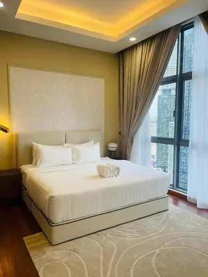 a bedroom with a white bed with a large window at Royce Residence KLCC by ABM Unique in Kuala Lumpur
