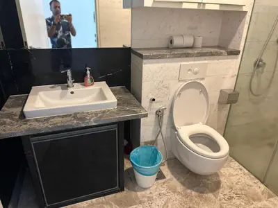 a man taking a picture of a bathroom with a toilet and sink at The Platinum Galaxy Suites KLCC in Kuala Lumpur