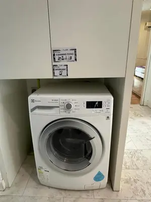 a washer and dryer under a white cabinet at The Platinum Galaxy Suites KLCC in Kuala Lumpur