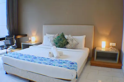 a bedroom with a large white bed with two lamps at The Platinum Galaxy Suites KLCC in Kuala Lumpur