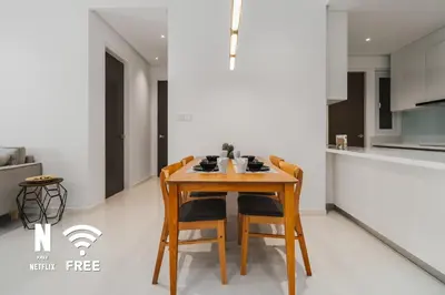 a kitchen with a wooden table and chairs at Elegant 2BR Residence at MET 1 in Kuala Lumpur