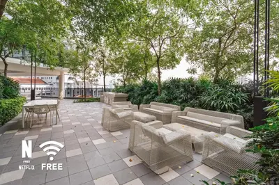a patio with couches and tables and trees at Elegant 2BR Residence at MET 1 in Kuala Lumpur