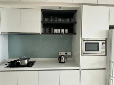 a kitchen with white cabinets and a microwave at Global Suites at Platinum kLCC in Kuala Lumpur