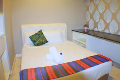 a small bedroom with a bed with a towel on it at Global Suites at Platinum kLCC in Kuala Lumpur