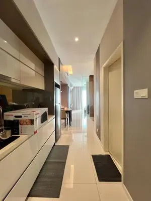 a kitchen with white cabinets and a table at Dorsett Hartamas - Luxury Studio with Bathtub in Kuala Lumpur