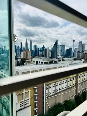 a view of a city skyline from a window at KLCC View Apartment in Kuala Lumpur