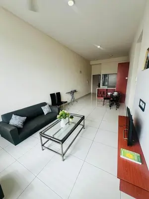 a living room with a black couch and a table at KLCC View Apartment in Kuala Lumpur