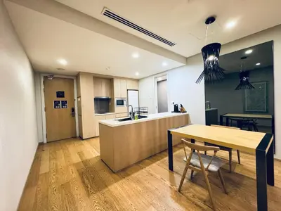 a kitchen with a wooden table and a dining room at 188 suites Apartment with KLCC View by Vho'Z in Kuala Lumpur