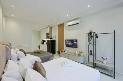 a living room with two beds and a tv at Majestic Residence near KLCC Quill City 1 in Kuala Lumpur