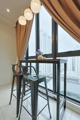 a dining room with a table and chairs in front of a window at Majestic Residence near KLCC Quill City 1 in Kuala Lumpur